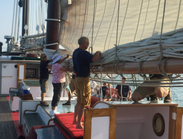 Doug Otte (in foreground) helps the crew to flake one of the massive sails on Liberty Clipper.