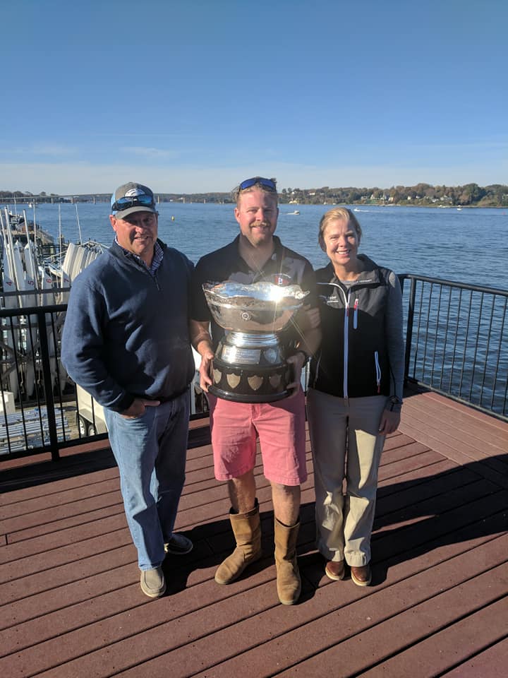 Kyle Comerford of SUNY Maritime with his trophy and his parents, Ken and Jennifer. Photo Annapolis YC Regattas Facebook page