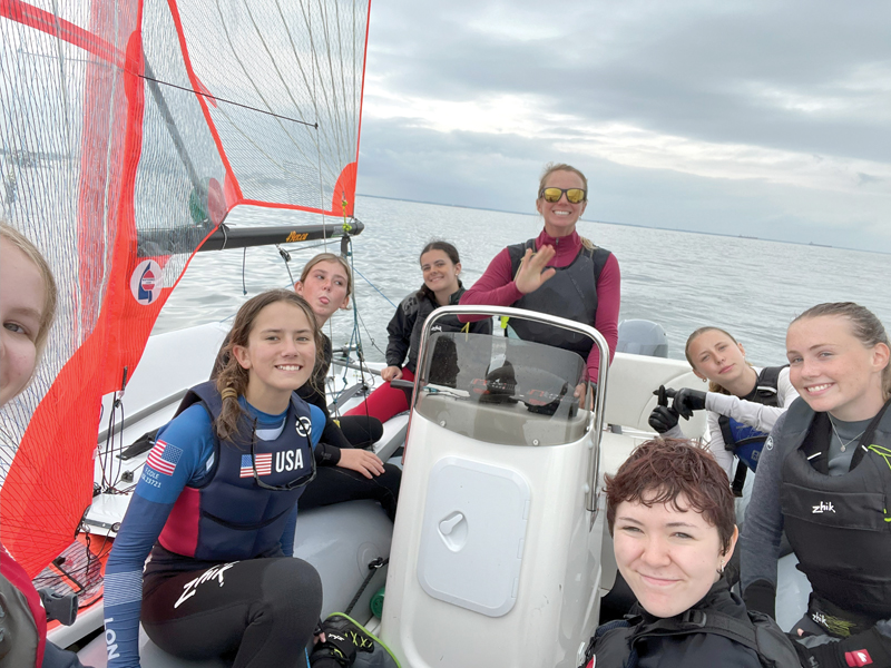 Youth sailing coach and young sailors on the water