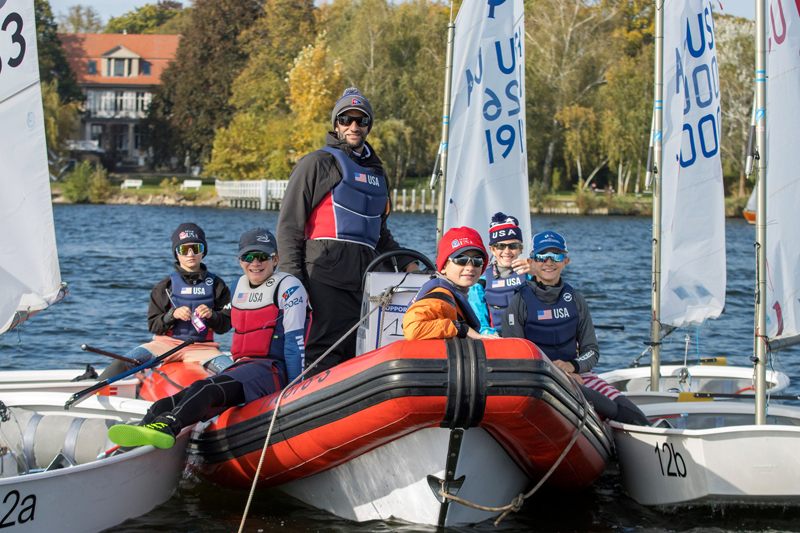 Youth sailors and coach on the water