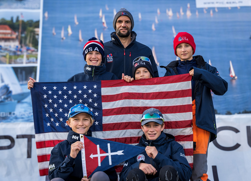 Youth sailors and coach with American flag