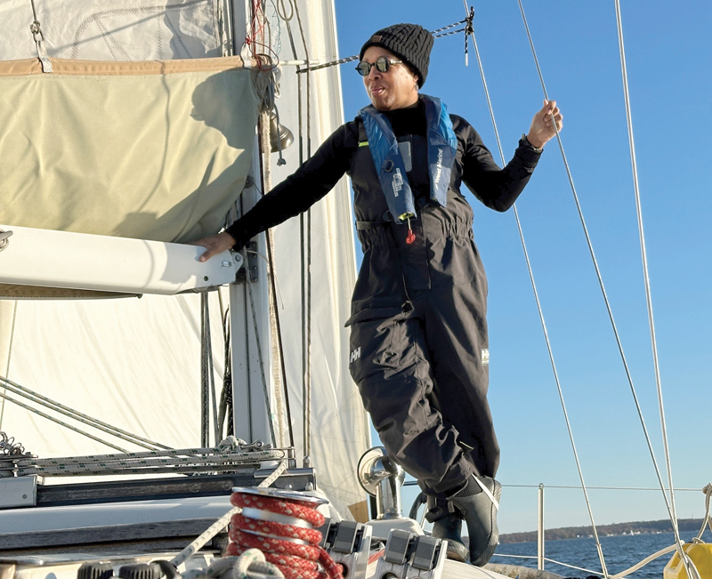 sailor standing at mast of sailboat