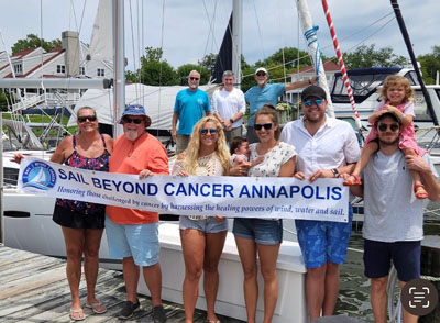 Sail Beyond Cancer banner with people on dock