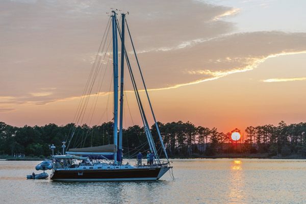 Sailboats at anchor with sunset in background