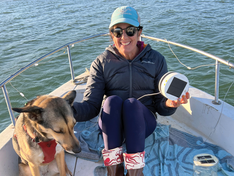 woman and dog on boat displaying green gifts for sailors